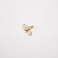 Gold bee-shaped earring on a light gray background