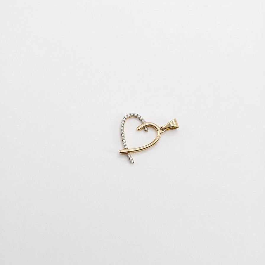 Gold heart-shaped earring on a light gray background