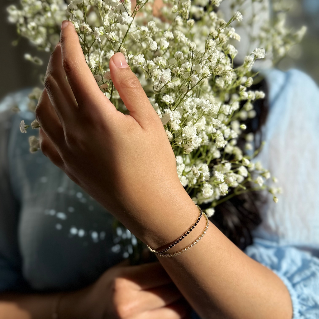 Person holding a bouquet of small white flowers with a blurred background